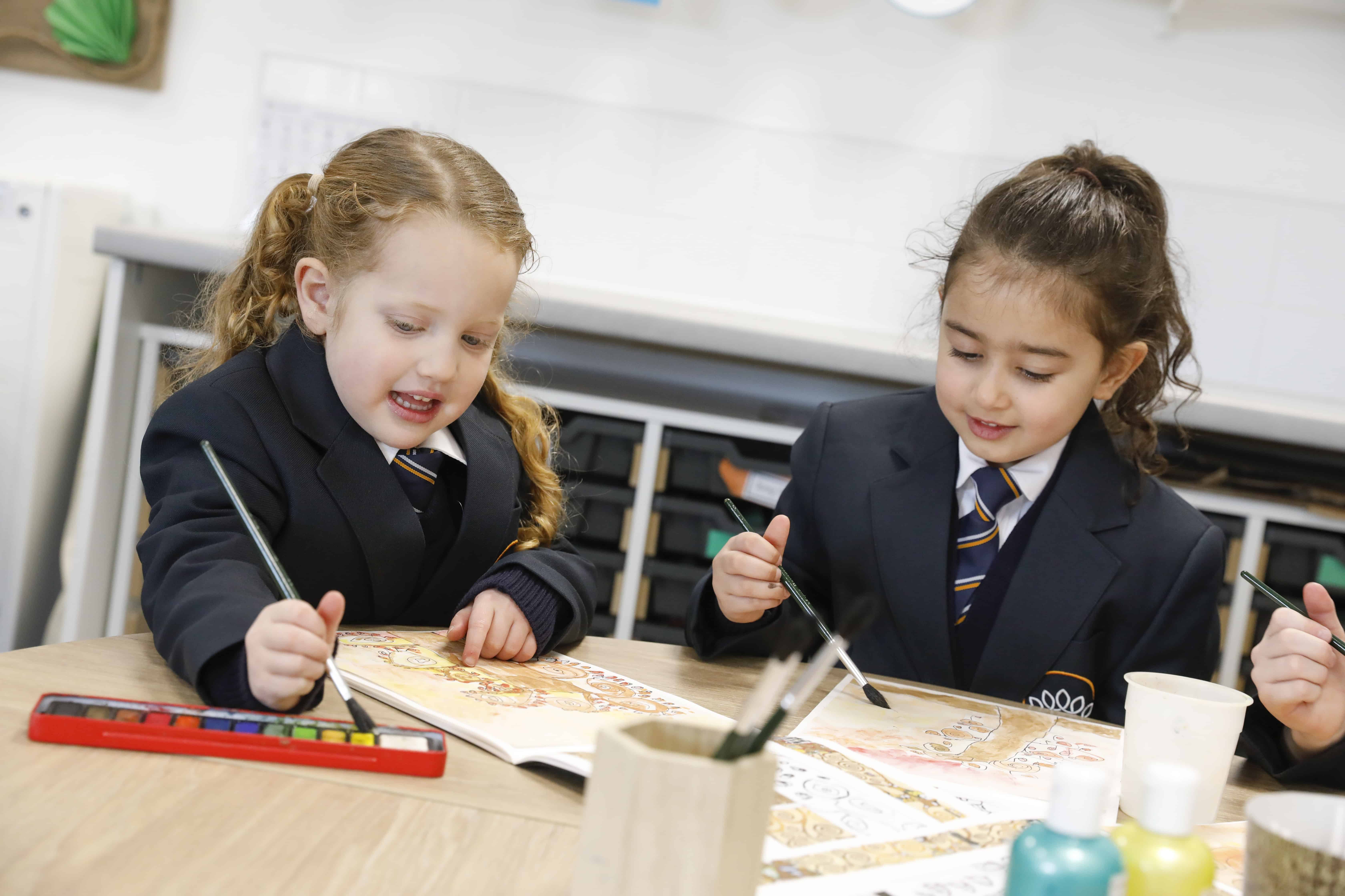 Two reception pupils painting pictures at Crown Street Primary School.